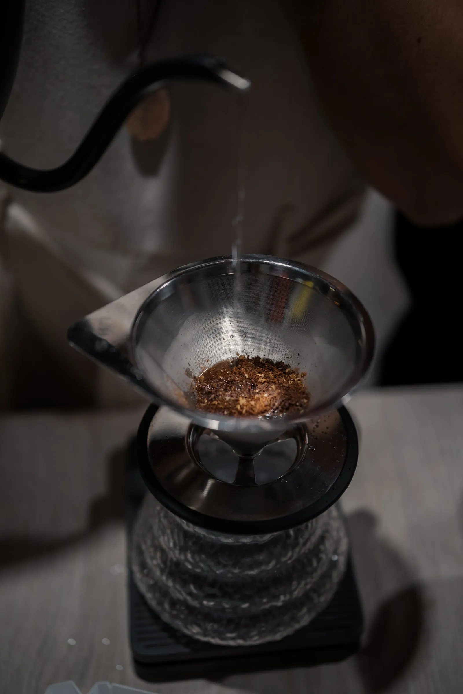 Café de filtro vertiéndose en un V60, a contraluz
